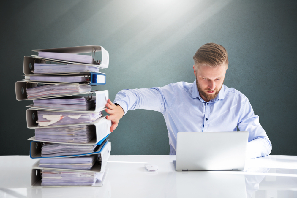 Businessperson Pushing Paper Documents Away And Working With Digital Documents On Computer Instead