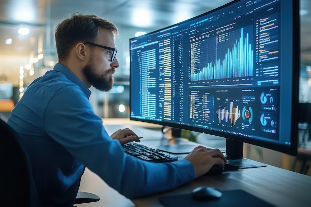 IT manager reviewing system logs on a large desktop screen, system performance review, IT assessment