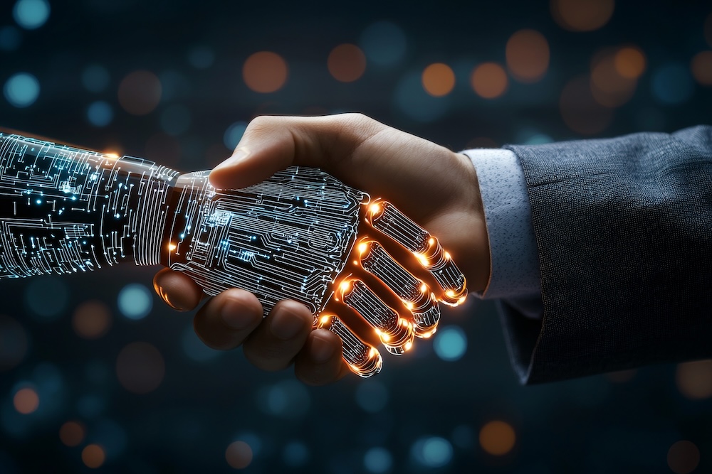 A hand is shaking a robot's hand. The robot is made of wires and circuits. Concept of AI automation, how a MSP can help.